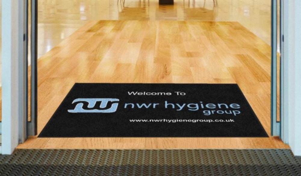 Branded floor mat in entryway to business, branded with NWR logo and company title