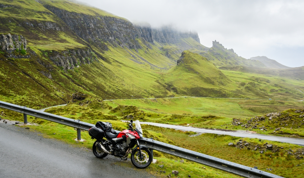 red motorcycle next to the cliffs of Lochaber