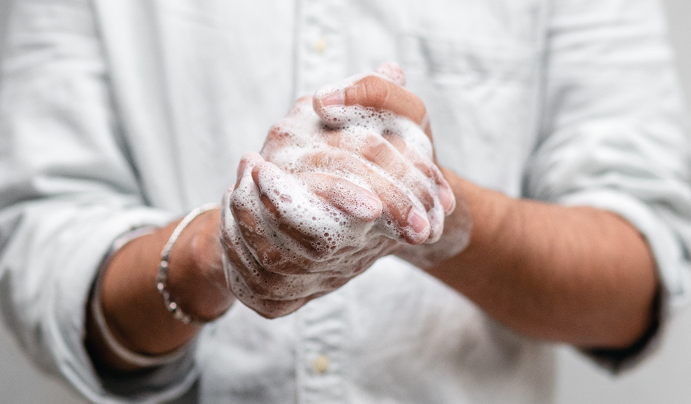 man using hygiene services in bathroom (soap dispenser) to wash his hands