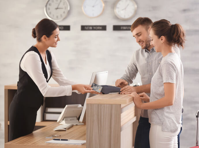 Couple at reception desk in hotel facility