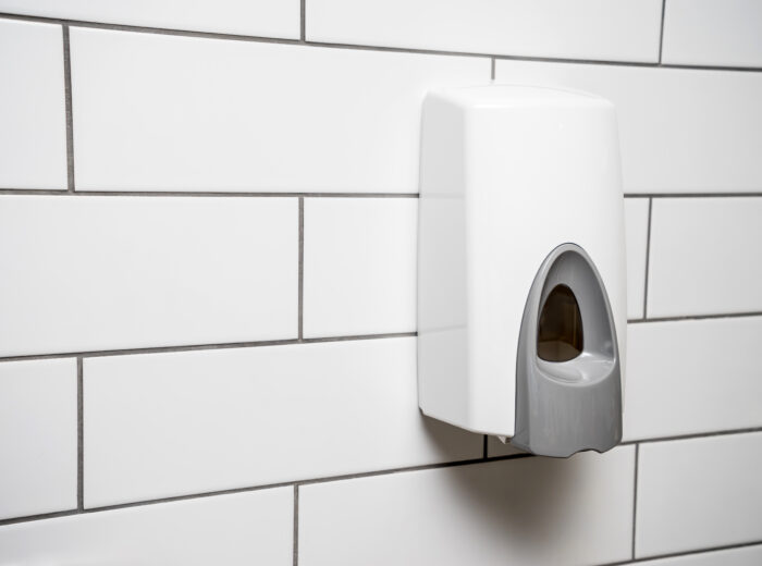 luxury foam soap dispenser on white tiled wall