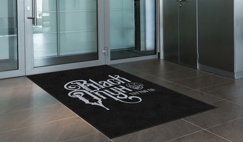 Commercial entrance mats in the entranceway to a tattoo parlour. 