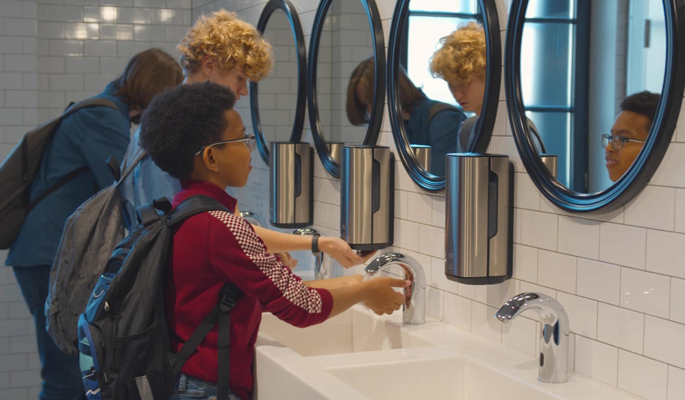 Children washing hands with soap and water in school washrooms. 