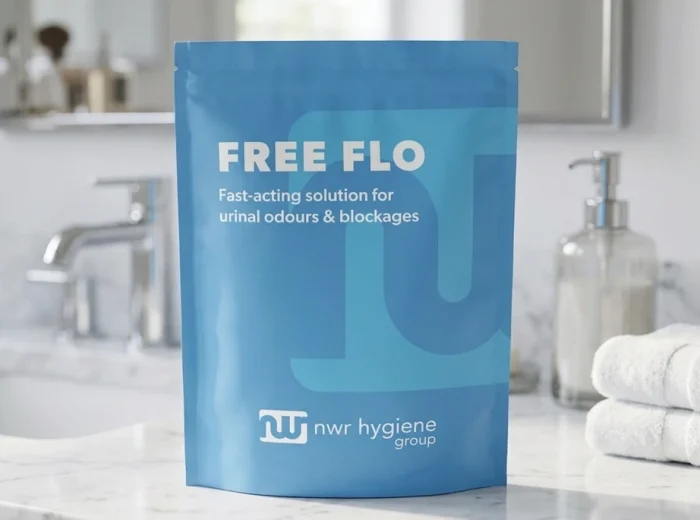 A blue NWR Hygiene Group Free Flo packet, sitting on a white marbled bathroom counter.