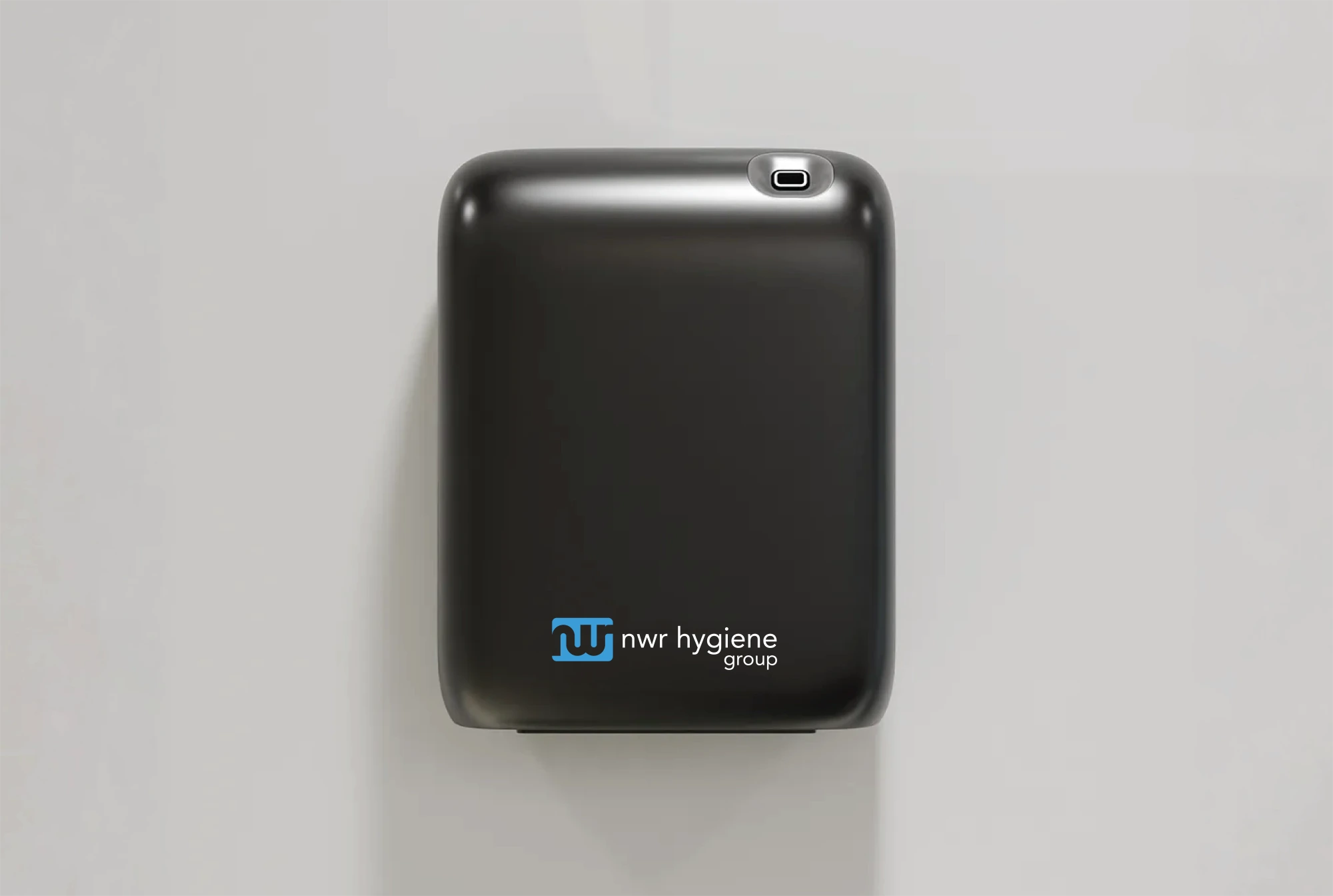 A sleek, black wall-mounted air freshener or hygiene dispenser from NWR Hygiene Group.