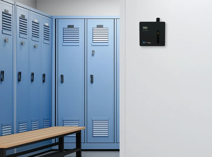 Black wall-mounted ScentVision SV1000 in a changing room with blue lockers and brown wooden benches.