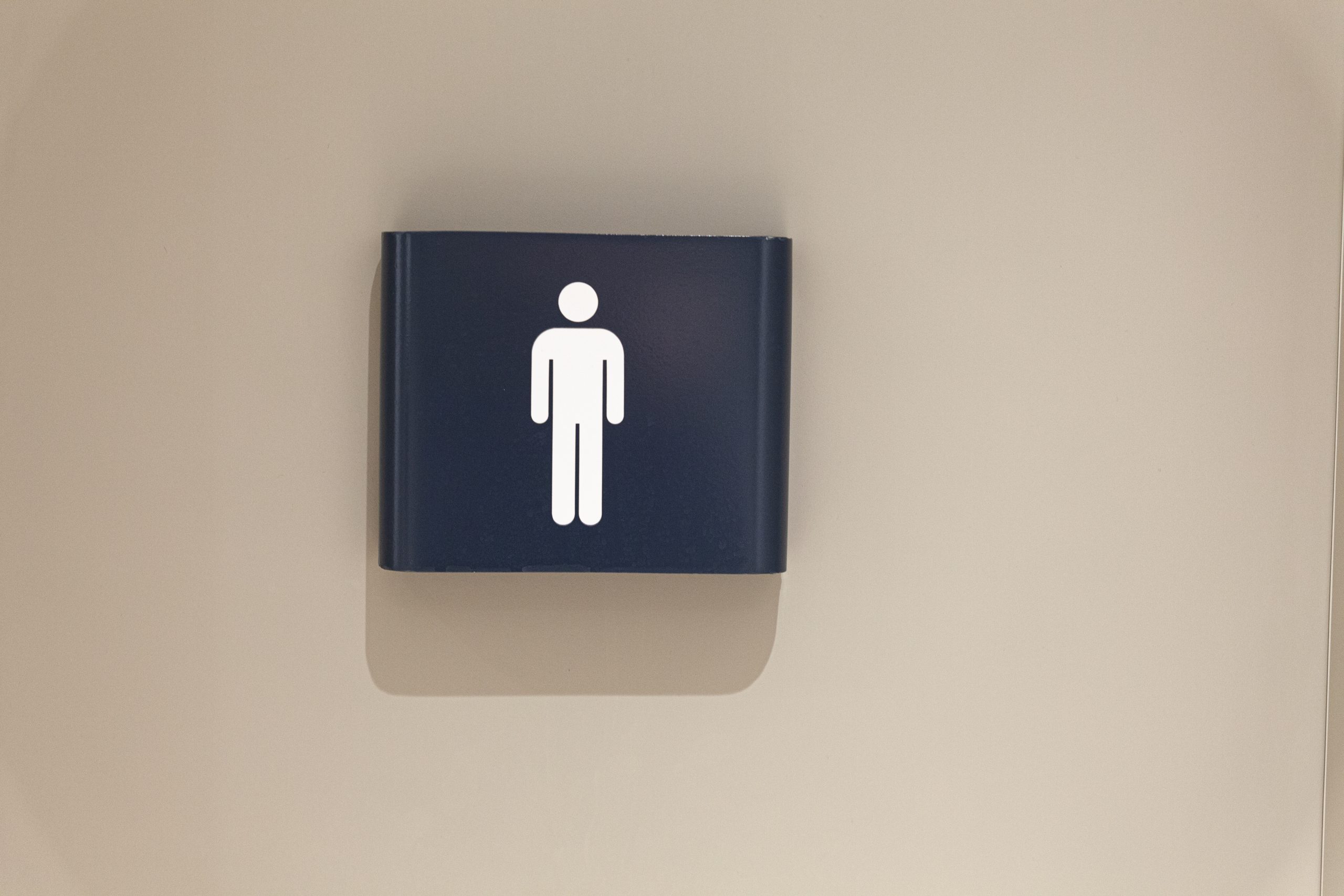 A male bathroom sign on a white wall.